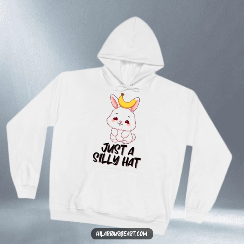 Funny bunny hoodie, a fluffy bunny wiggling its nose with a tiny banana peel on its head, radiating adorable charm and playful silliness.