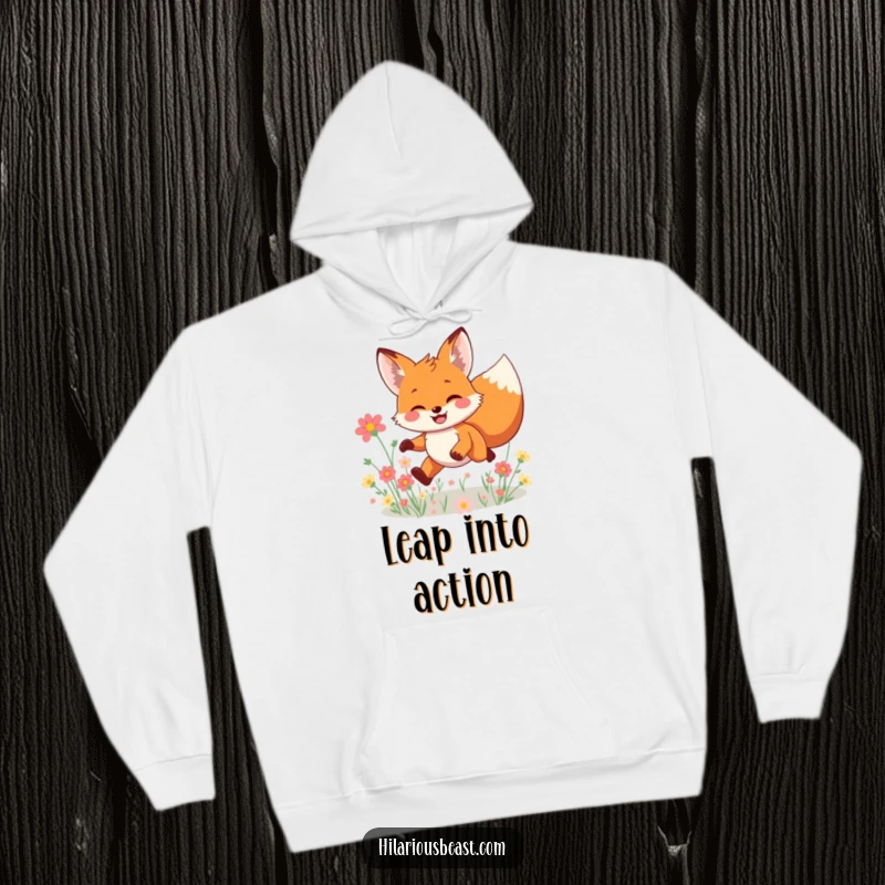 Funny smiling fox hoodie featuring a character leaping joyfully through a field of flowers, radiating warmth, playfulness, and charming happiness for a humorous experience.