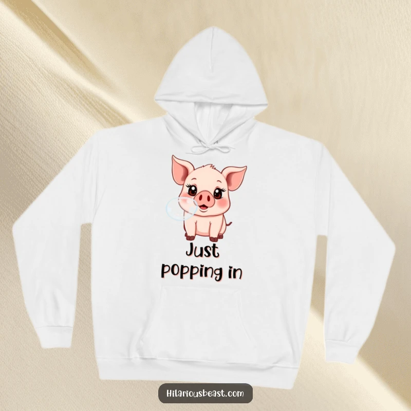 Funny, wide-eyed piglet happily blowing a big bubble, featured on a comfortable hoodie, radiating pure joy.